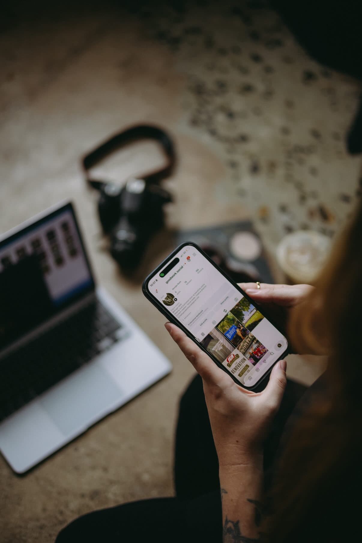 A phone showing the @goodwork.social Instagram feed